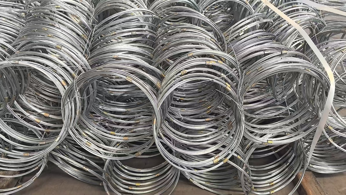 Ring net barrier stock in the workshop — interlocked steel rings before rolling